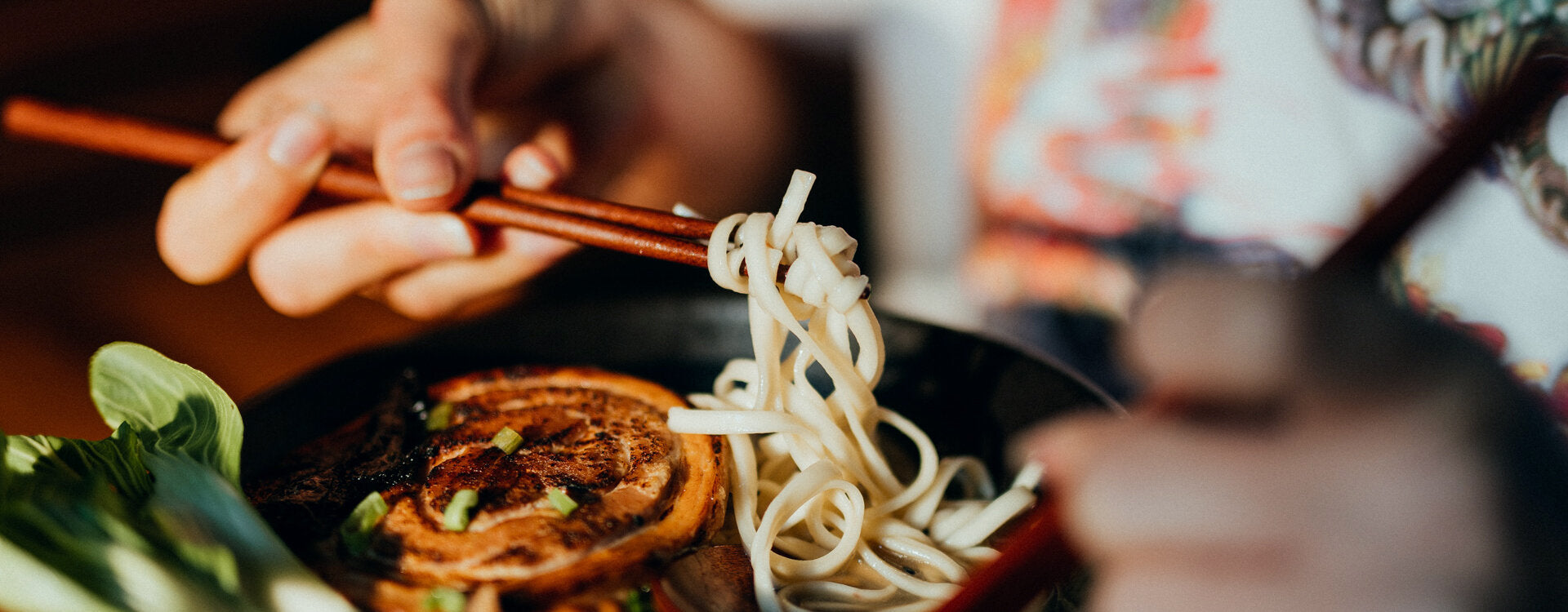 Nahaufnahme einer Person, die gerade Lucky Ramen ist mit Fokus auf die Nudeln